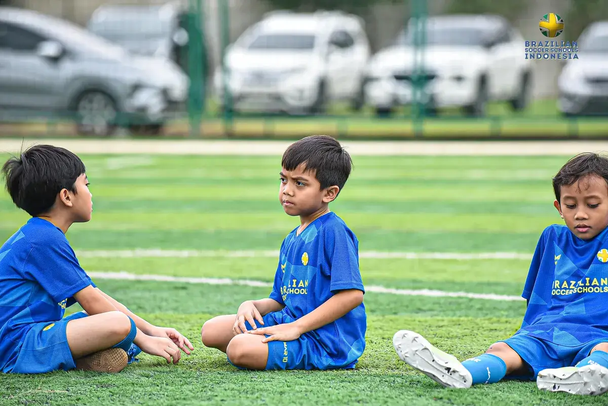 Anak-anak beristirahat bersama di lapangan