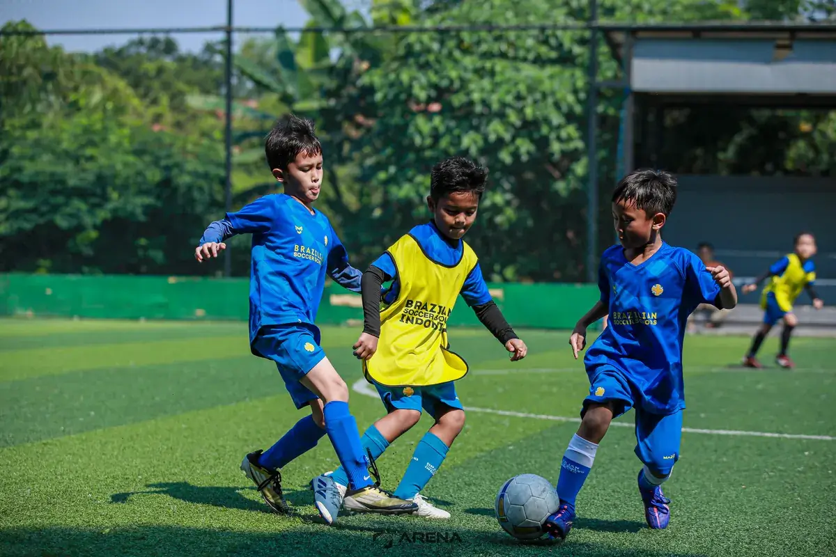 Anak-anak berebut bola sambil melatih kelincahan