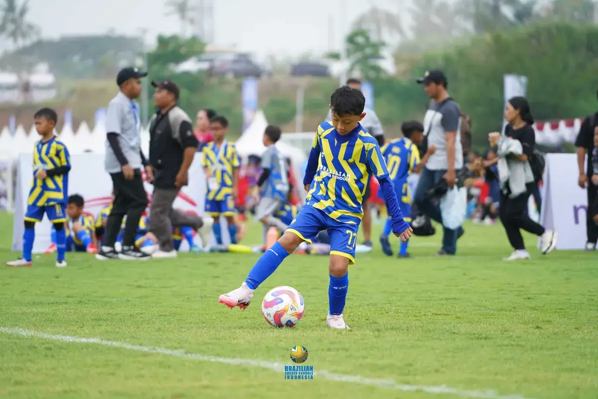 Anak berlari di lapangan sepak bola yang luas