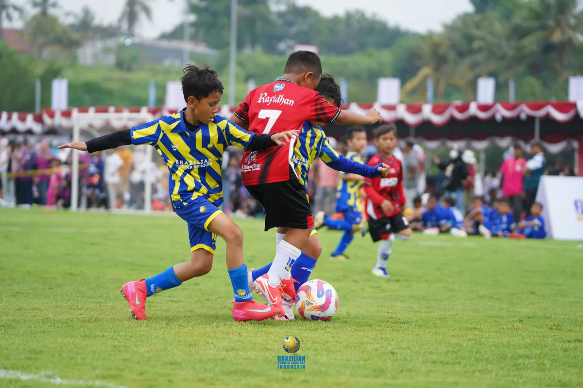 Anak bertanding sepak bola dalam sebuah turnamen