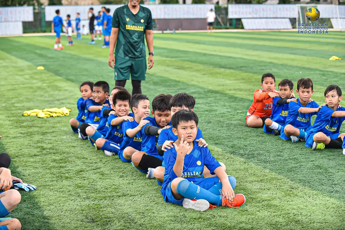 Anak tersenyum bersama teman satu tim