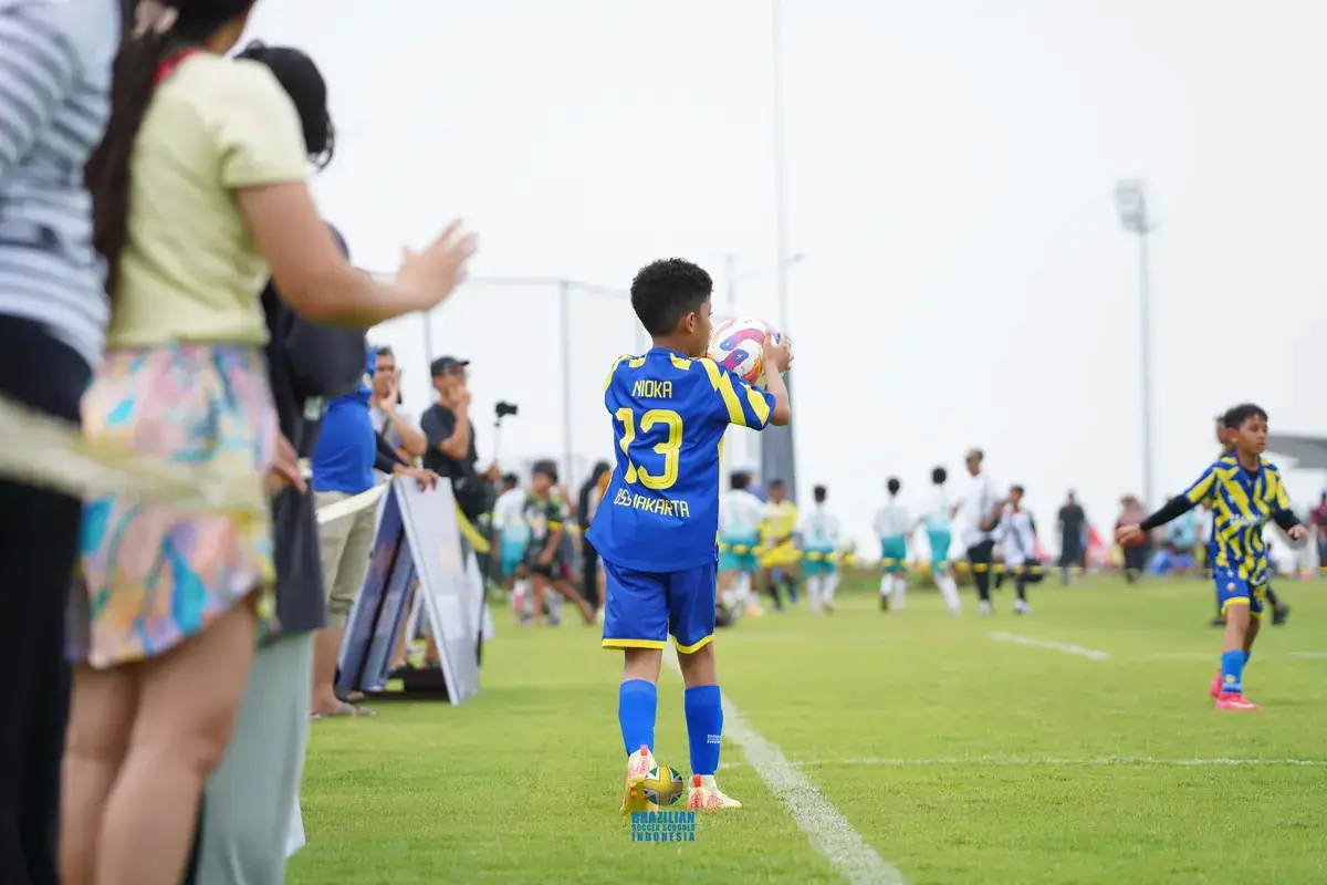 Ibu mendampingi anak di pinggir lapangan