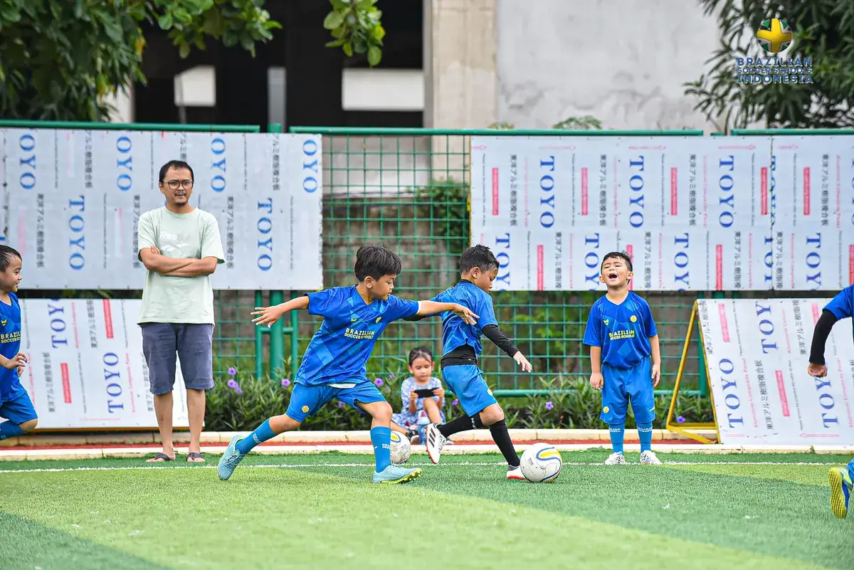 Orang tua menonton sesi latihan dari pinggir lapangan