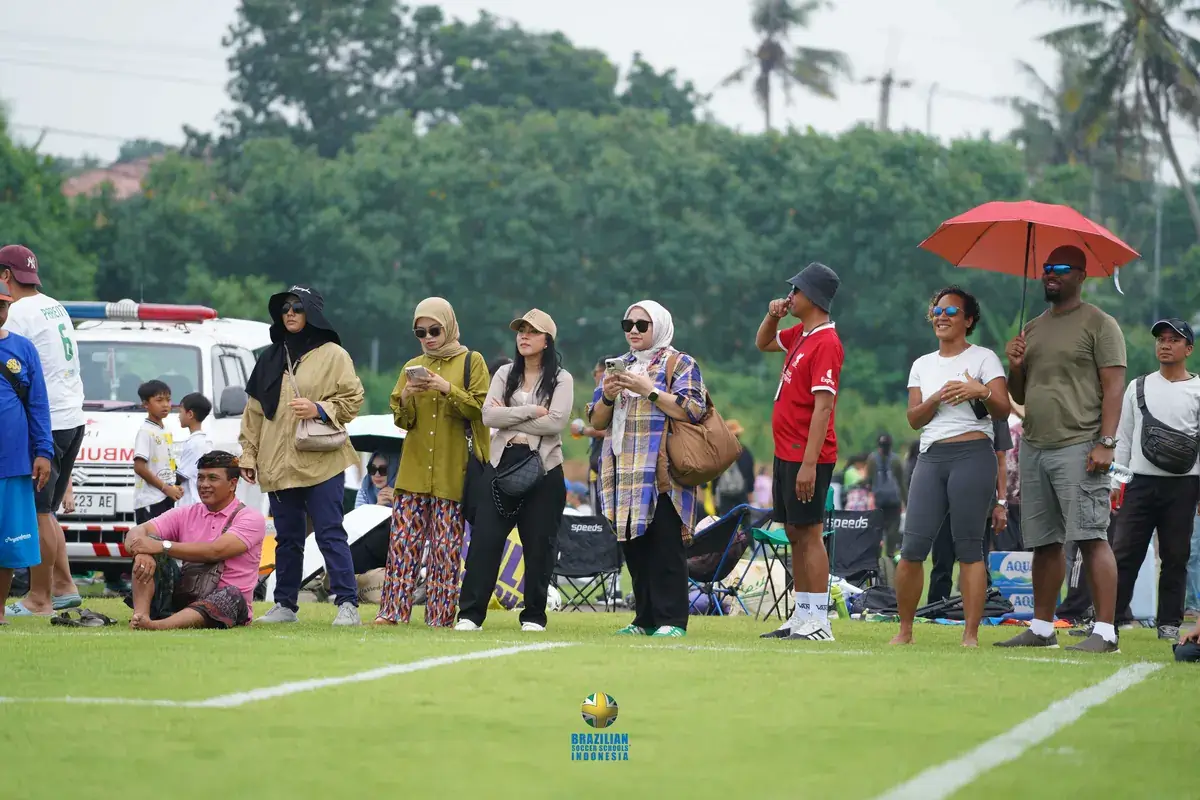 Peran orang tua dalam olahraga anak: para orang tua menonton anak bertanding di pinggir lapangan