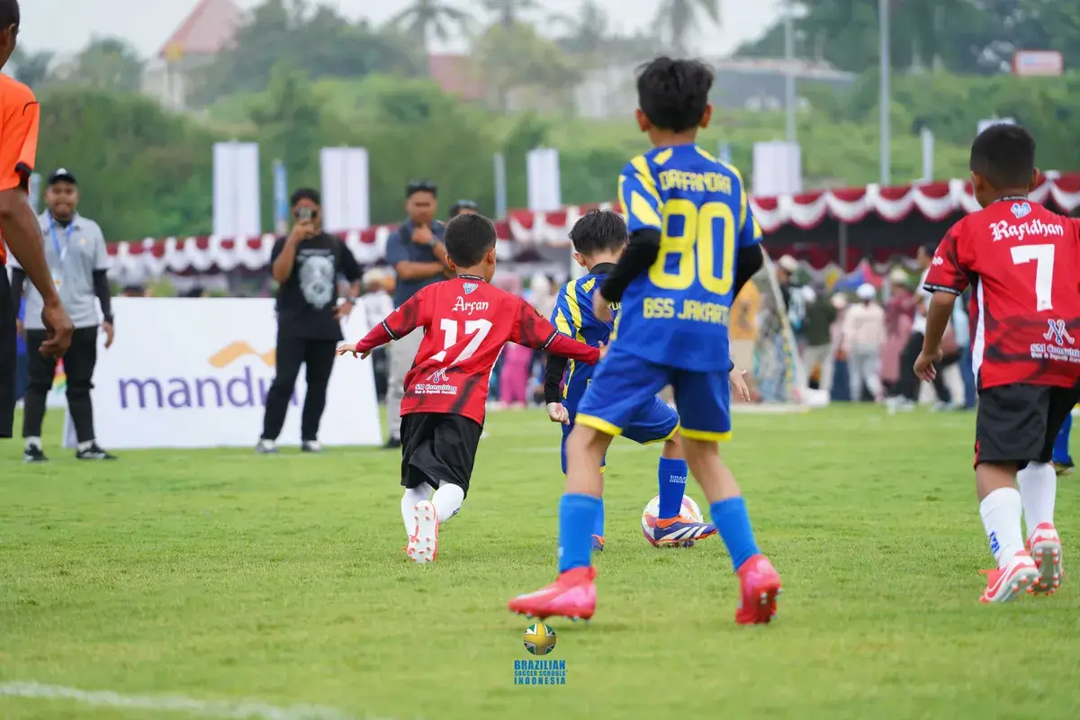 Pertandingan sepak bola anak di lapangan rumput