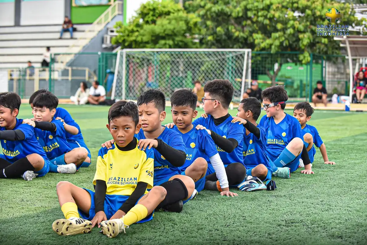 Tim anak duduk bersama setelah sesi latihan sepak bola